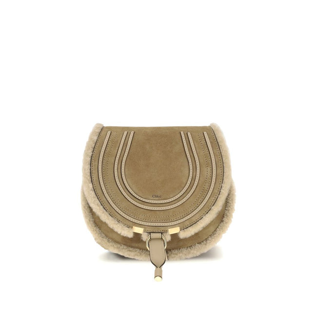 Beige Calf Leather Bos Taurus Shoulder BagSmall Saddle Marcie Shoulder Bag by Chloé reinterprets the house’s iconic equestrian aesthetic in a warm, textured key. Crafted in suede with shearling details, it is distinguished by its rounded silhouette and st