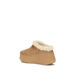 Nama Wedge MulesThe Nama Wedge Mules by Chloé blend casual elegance with artisanal mastery. Crafted from suede calfskin and shearling, they feature a leather strap with the House’s signature Paddington buckle. The lightweight wedge, made from recycled mat