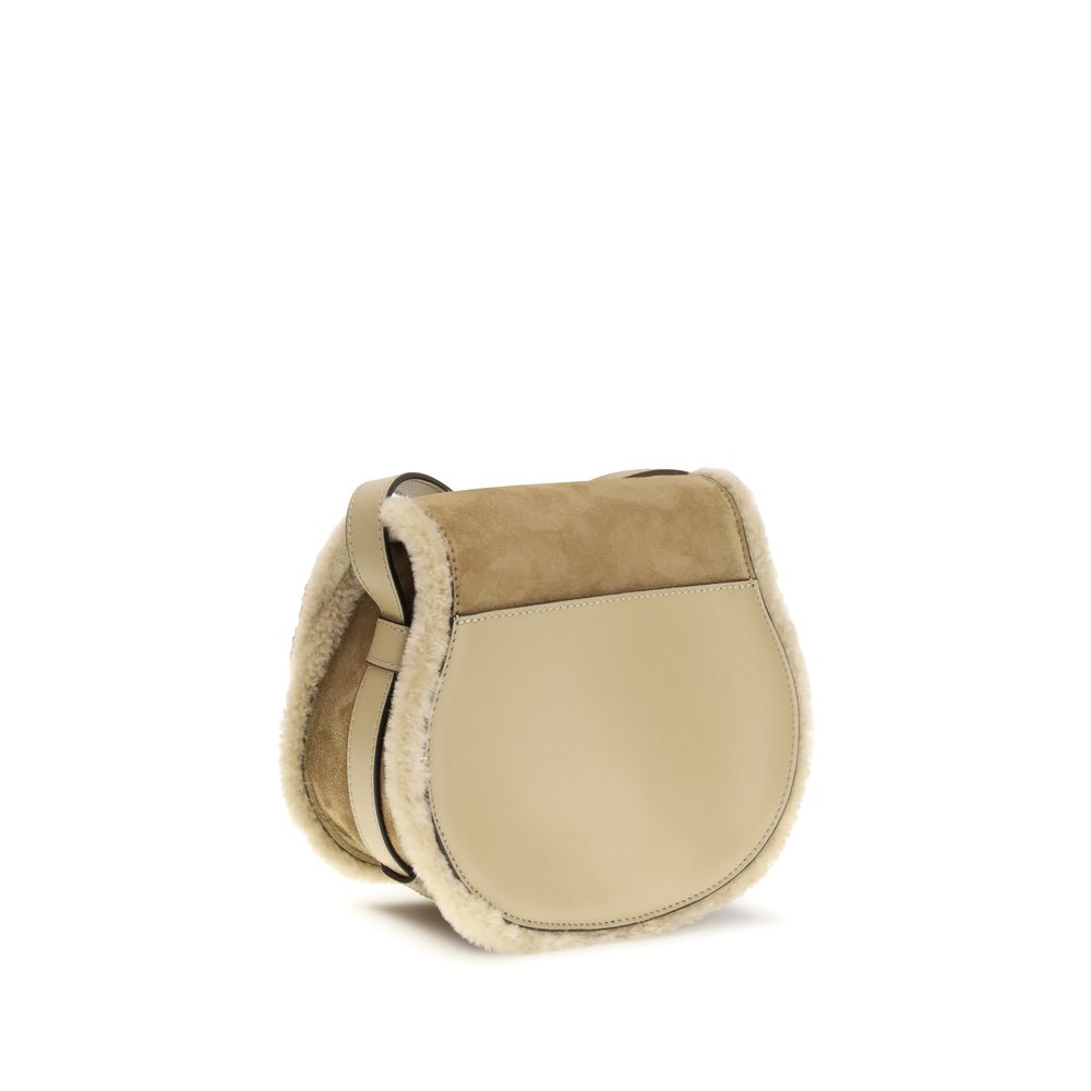 Beige Calf Leather Bos Taurus Shoulder BagSmall Saddle Marcie Shoulder Bag by Chloé reinterprets the house’s iconic equestrian aesthetic in a warm, textured key. Crafted in suede with shearling details, it is distinguished by its rounded silhouette and st
