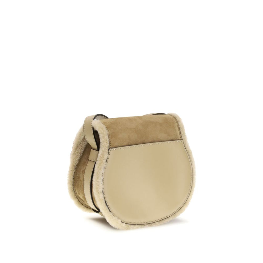 Beige Calf Leather Bos Taurus Shoulder BagSmall Saddle Marcie Shoulder Bag by Chloé reinterprets the house’s iconic equestrian aesthetic in a warm, textured key. Crafted in suede with shearling details, it is distinguished by its rounded silhouette and st