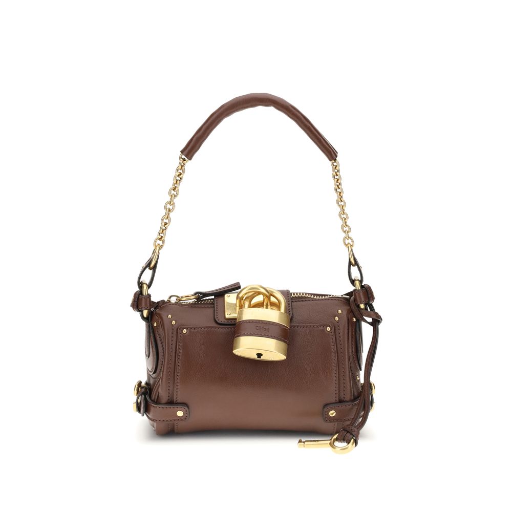 Paddington Shoulder BagPaddington Shoulder Bag by Chloé, crafted from soft garnet buffalo leather, stands out for its compact and flexible silhouette. Featuring a practical top zipper, it is embellished with iconic details such as an oversize padlock, C-s