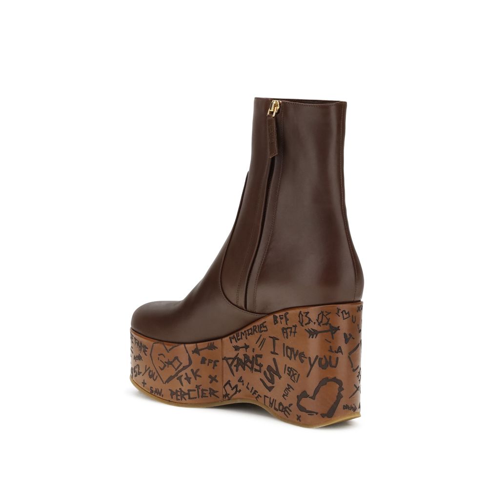 Brown Leather BootsMaxime wedge Ankle Boots by Chloé are a romantic homage to the Maison’s craftsmanship and identity. Made of glossy calfskin, they are distinguished by a wood-effect platform structure that recalls the natural and poetic aesthetic of a d