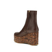 Brown Leather BootsMaxime wedge Ankle Boots by Chloé are a romantic homage to the Maison’s craftsmanship and identity. Made of glossy calfskin, they are distinguished by a wood-effect platform structure that recalls the natural and poetic aesthetic of a d