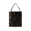 Brown Fur Shoulder BagLarge Spin Tote Bag by Chloè in soft shearling is distinguished by a compact, minimalist silhouette defined by clean graphic lines. The discreet elegance of the design is enhanced by a dangling chain with the iconic Chloé medals and
