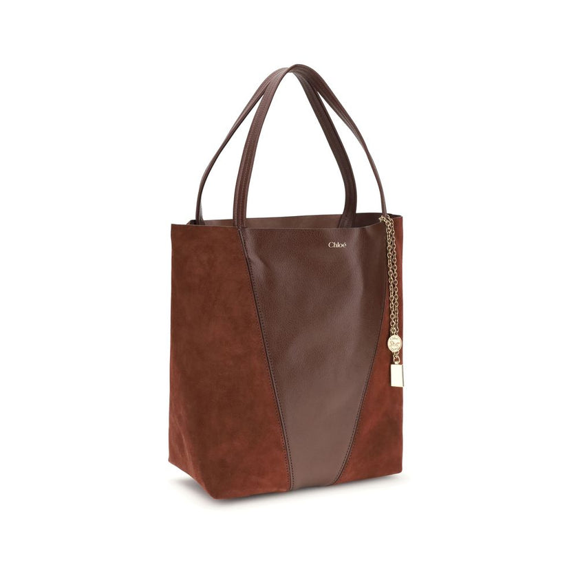Brown Leather Shoulder BagThe Spin Shoulder Bag by Chloè captures the effortless elegance of the French Maison. Crafted from a refined combination of grained leather and suede, it features a subtle laminated logo on the front. Two flat leather handles enh