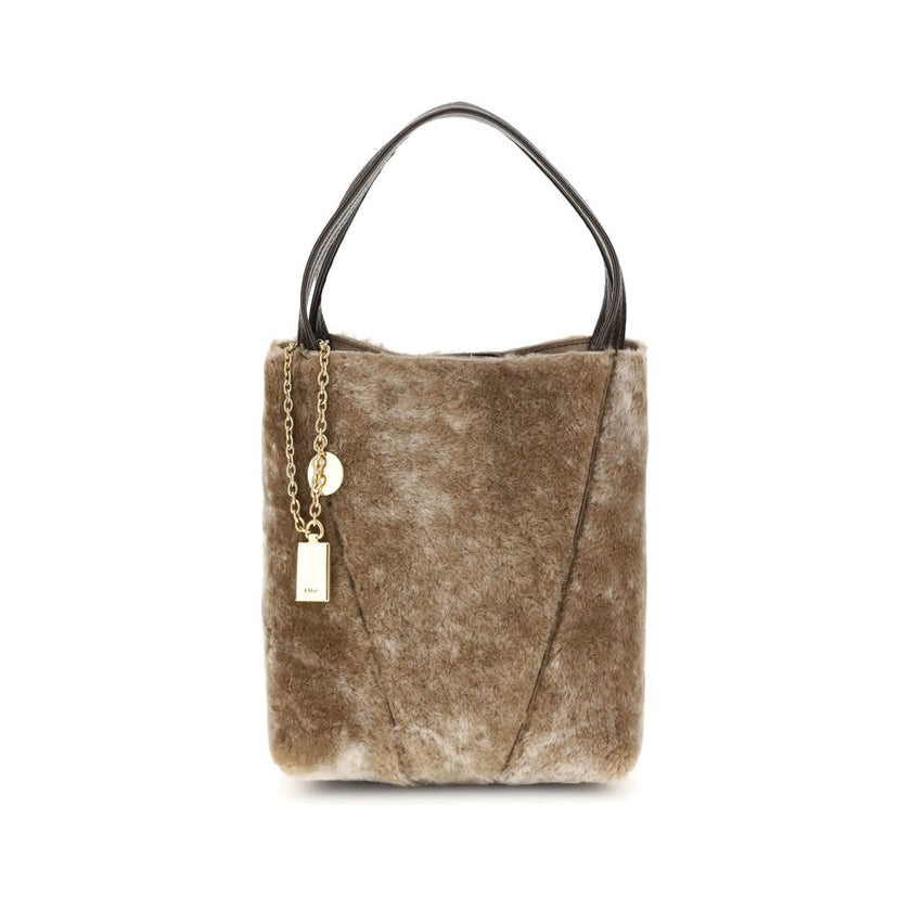 Beige Fur Shoulder BagSpin small Tote Bag by Chloè in soft shearling is distinguished by a compact, minimalist silhouette defined by clean graphic lines. The discreet elegance of the design is enhanced by a dangling chain with the iconic Chloé medals and