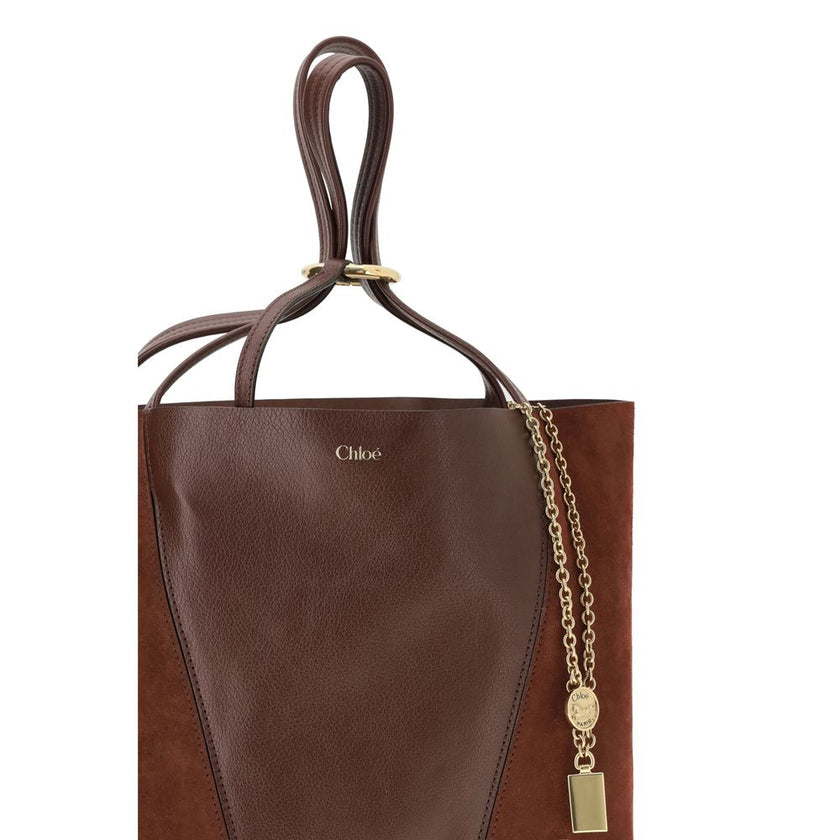 Brown Leather Shoulder BagThe Spin Shoulder Bag by Chloè captures the effortless elegance of the French Maison. Crafted from a refined combination of grained leather and suede, it features a subtle laminated logo on the front. Two flat leather handles enh