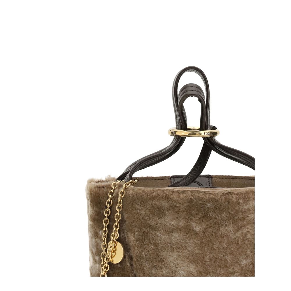 Beige Fur Shoulder BagSpin small Tote Bag by Chloè in soft shearling is distinguished by a compact, minimalist silhouette defined by clean graphic lines. The discreet elegance of the design is enhanced by a dangling chain with the iconic Chloé medals and