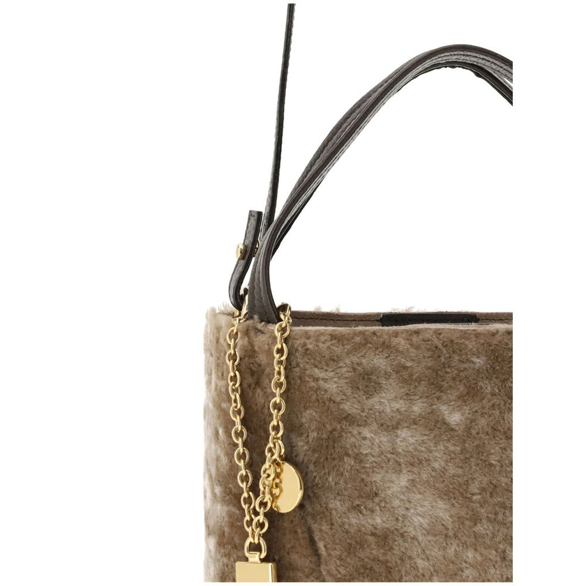 Beige Fur Shoulder BagSpin small Tote Bag by Chloè in soft shearling is distinguished by a compact, minimalist silhouette defined by clean graphic lines. The discreet elegance of the design is enhanced by a dangling chain with the iconic Chloé medals and