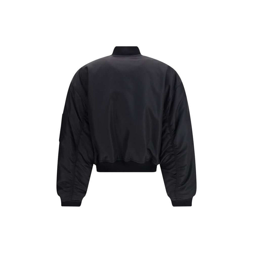 Black Polyamide BomberThe Standard Bomber offers a refined take on a timeless staple. Crafted from recycled satin-finish polyamide, it features ruched sleeves that add volume and character to the silhouette. A central zip closure and ribbed trims highligh