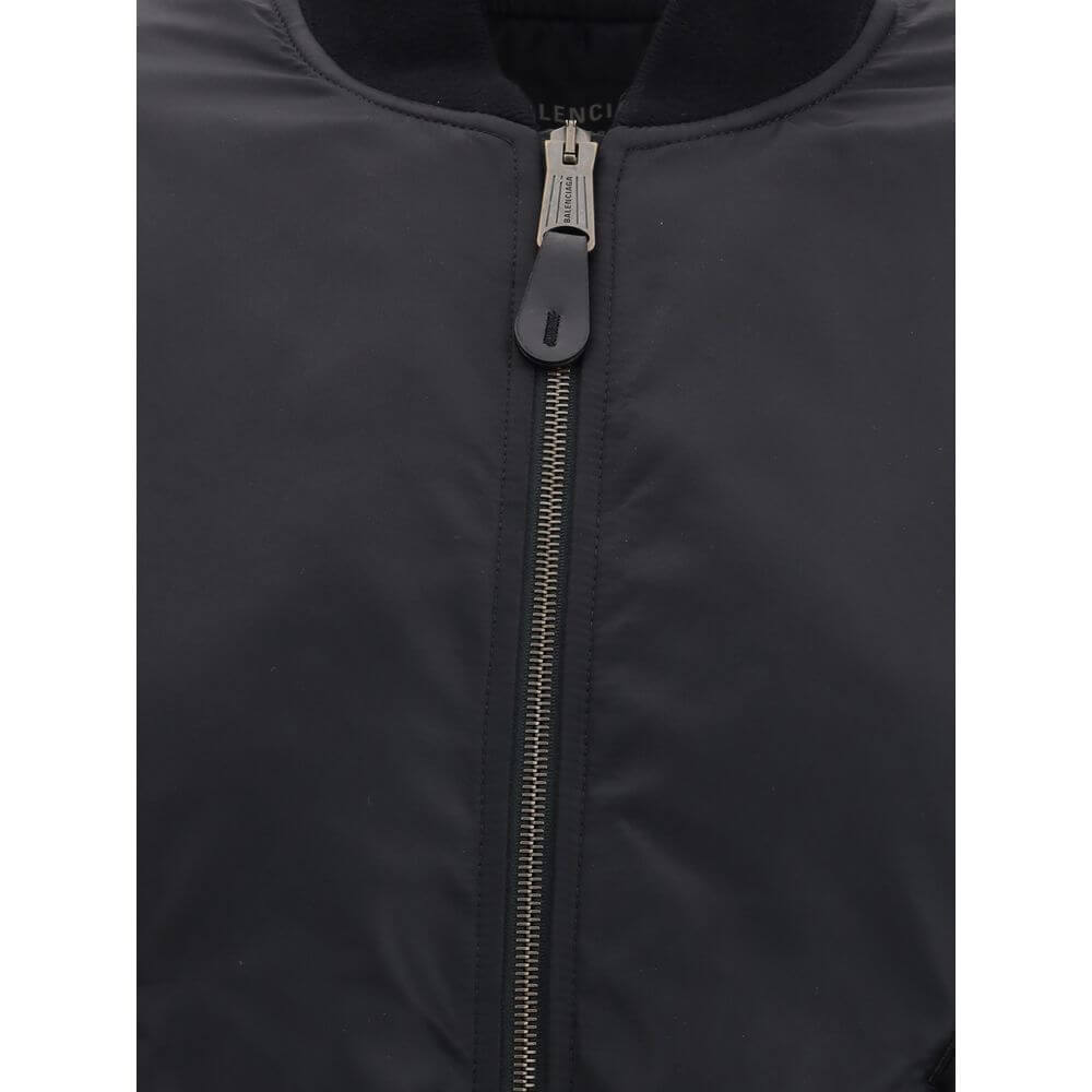 Black Polyamide BomberThe Standard Bomber offers a refined take on a timeless staple. Crafted from recycled satin-finish polyamide, it features ruched sleeves that add volume and character to the silhouette. A central zip closure and ribbed trims highligh