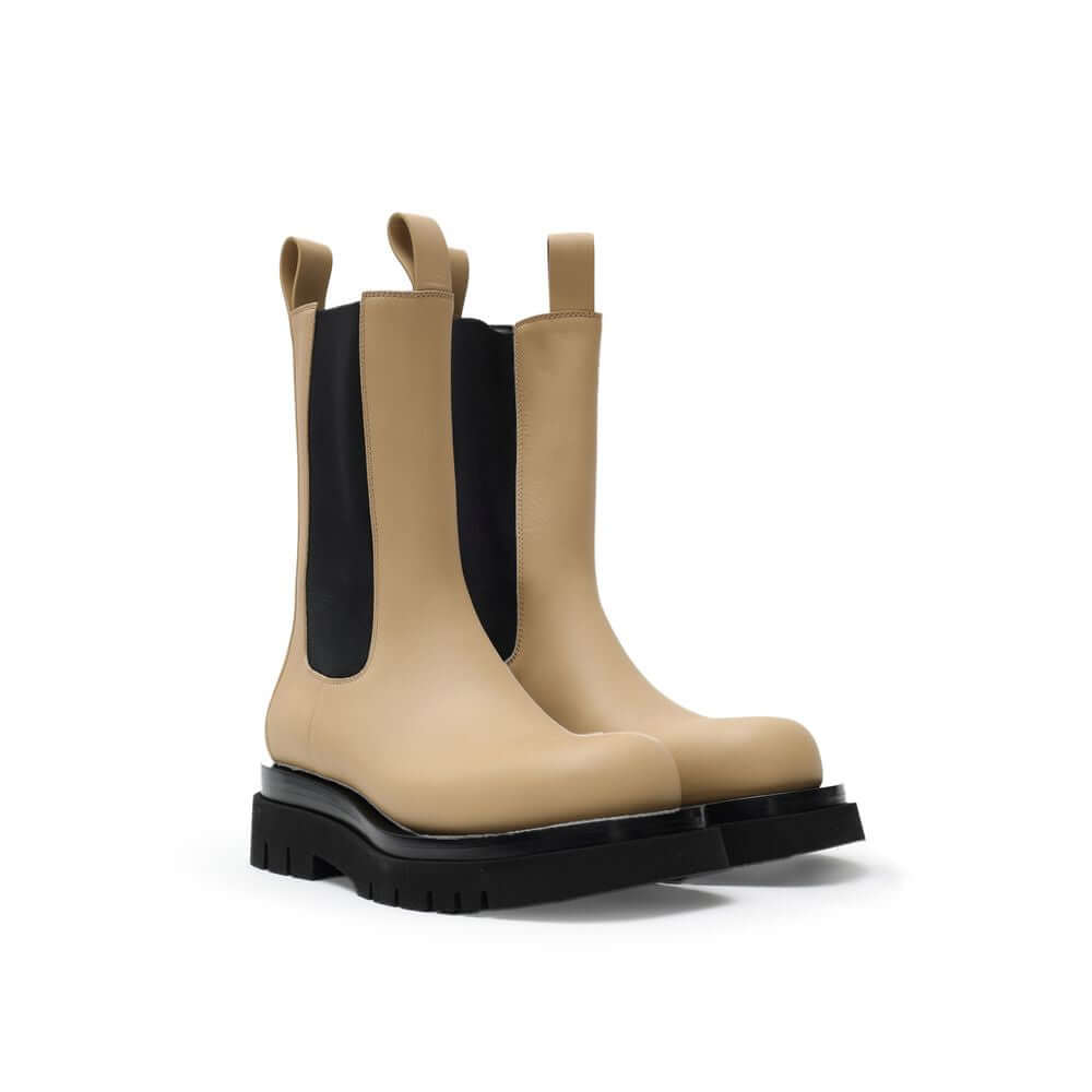 Beige Leather Chelsea BootsBeige and Black Leather Lug Ankle Boots by Bottega Veneta. Maxi black lug sole, round toe, brushed leather, contrasting elastic side bands, and shoehorn tabs on the front and back for comfortable wear. Composition: Leather Inter