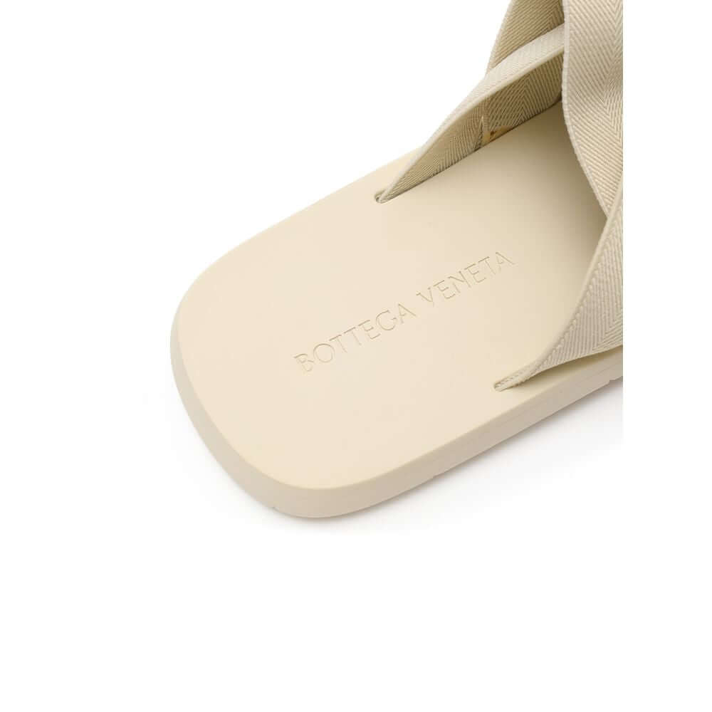 Beige Fabric SlippersBottega Veneta Beige Elastic Woven Rubber Slipper Sandals. In sand beige, rounded rubber sole, tone-on-tone elastic weave. Composition: Technical fabric, rubber. Internal SKU: 25OTT04 Brand SKU: 651402V0GV09031Beige Fabric Slippers${t