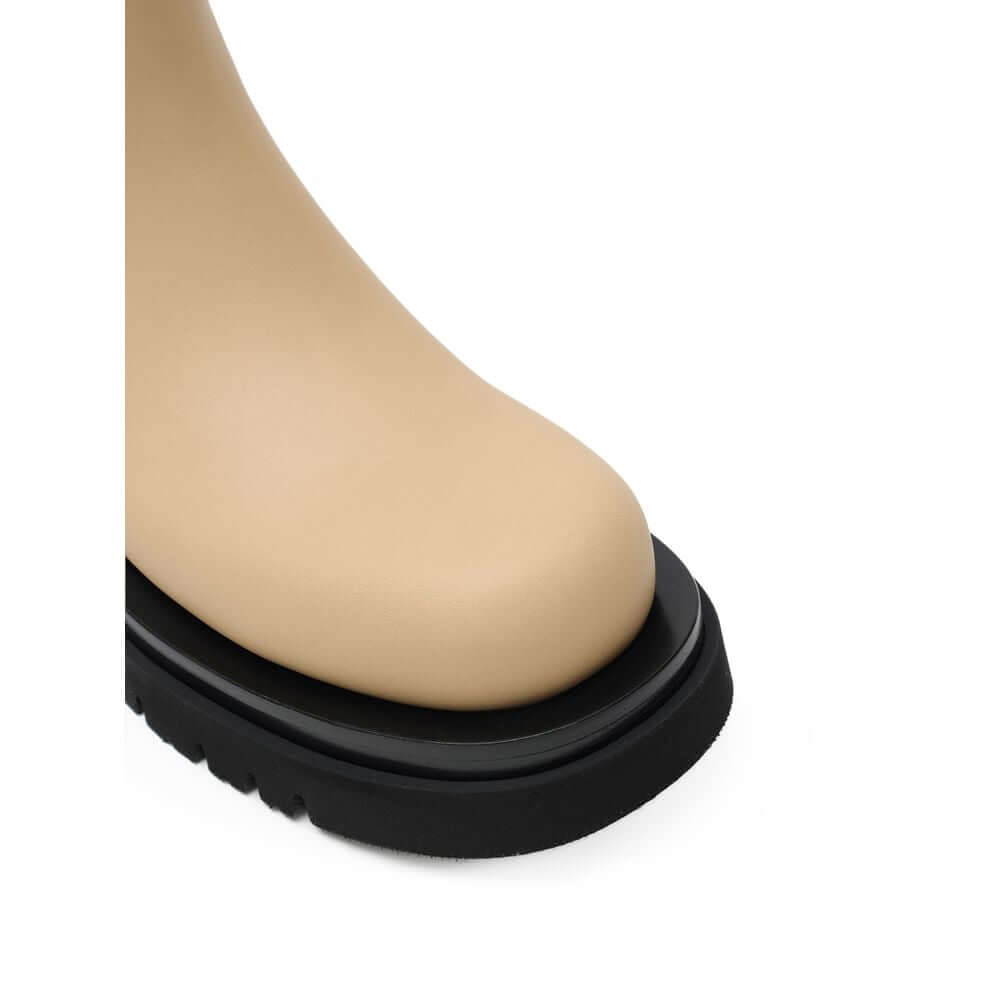 Beige Leather Chelsea BootsBeige and Black Leather Lug Ankle Boots by Bottega Veneta. Maxi black lug sole, round toe, brushed leather, contrasting elastic side bands, and shoehorn tabs on the front and back for comfortable wear. Composition: Leather Inter