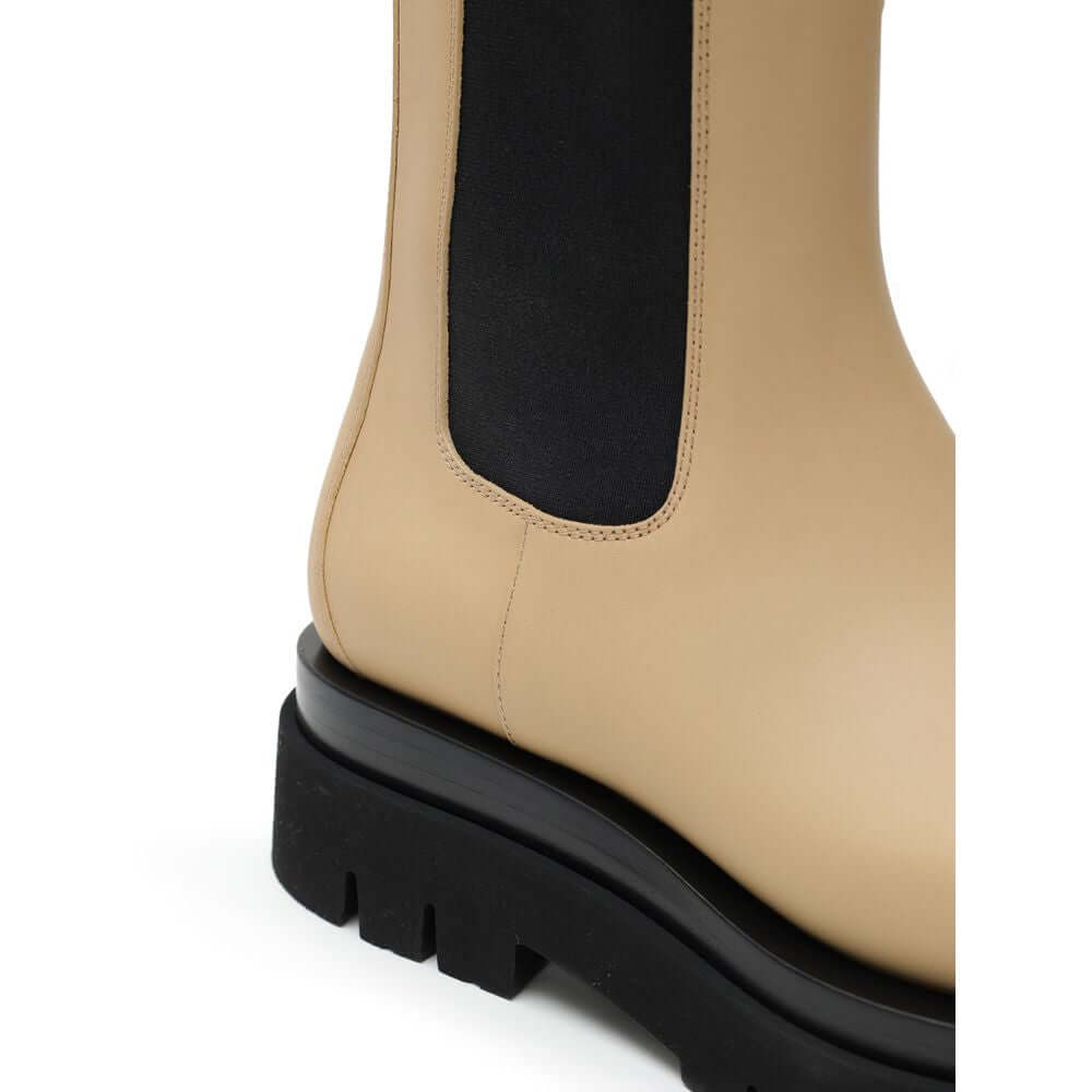 Beige Leather Chelsea BootsBeige and Black Leather Lug Ankle Boots by Bottega Veneta. Maxi black lug sole, round toe, brushed leather, contrasting elastic side bands, and shoehorn tabs on the front and back for comfortable wear. Composition: Leather Inter