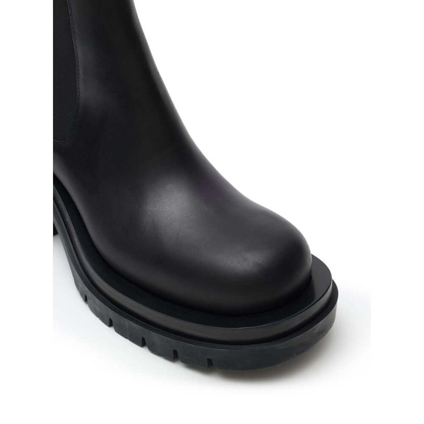 Black Leather Ankle BootsBottega Veneta Black Leather Lug Ankle Boots. Maxi black lug sole with heel, round toe, brushed leather, elastic side bands, and a pull-tab at the back for easy on and off. Composition: Leather Internal SKU: 25OTT03 Brand SKU: 667