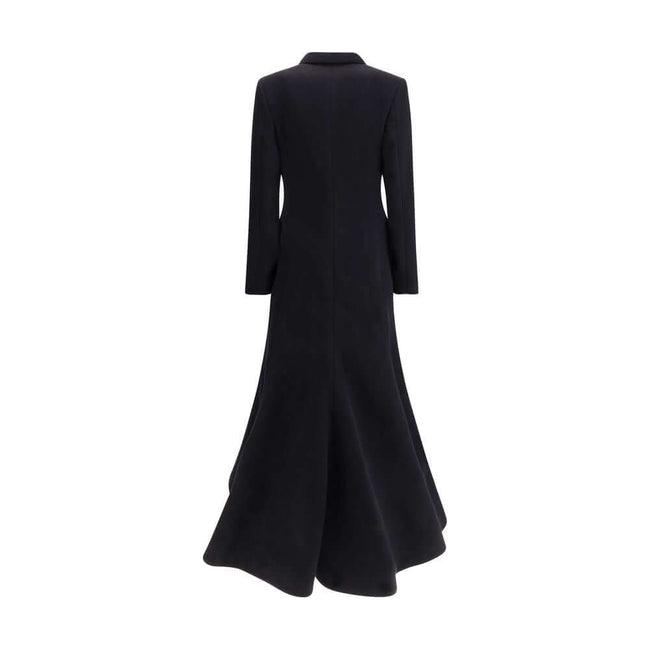 Black Wool CoatThe oversized double-breasted Coat by Balenciaga is an icon of contemporary elegance, blending sartorial precision with bold proportions. Crafted from a luxurious black wool and cashmere blend, it features a wide, structured silhouette enha