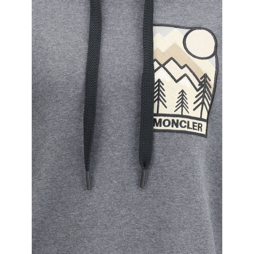 Gray Cotton SweatshirtThe Moncler Grenoble mountain-logo Hoodie blends functionality with sporty elegance. Crafted from soft cotton-blend fleece, it features a relaxed silhouette, an adjustable hood, and an embroidered logo patch on the chest, evoking the