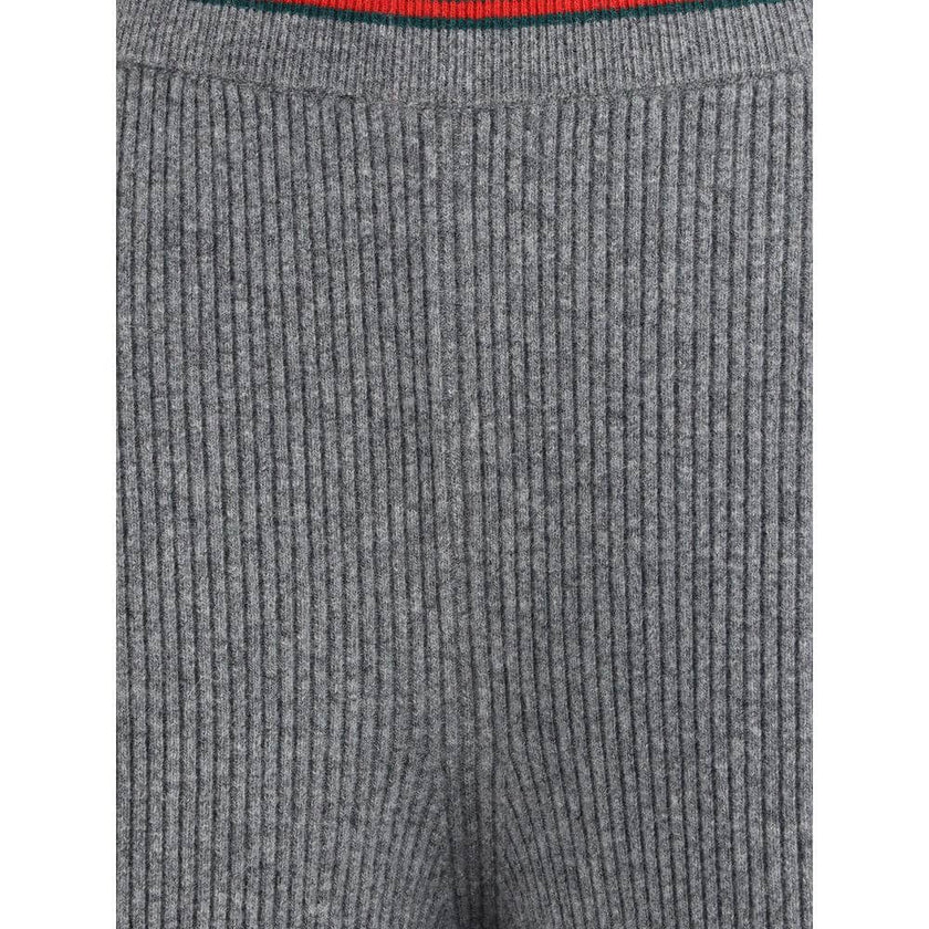 Gray Wool Casual PantsThe ribbed Wool Trousers by Gucci highlight the House’s signature codes with the green and red Web trim accenting the waistband and hem. Cut with a wide leg for a relaxed yet refined silhouette, the trousers feature an elasticated wa