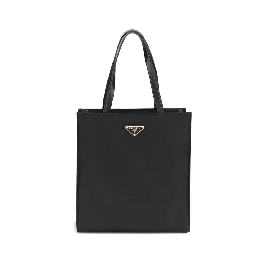 Black Recycled Polyamide Shoulder BagRe-Nylon Tote Bag by Prada features a functional and elegant design. Equipped with two leather handles, it features the iconic triangular plaque on the front and an adjustable and removable nylon shoulder strap for add
