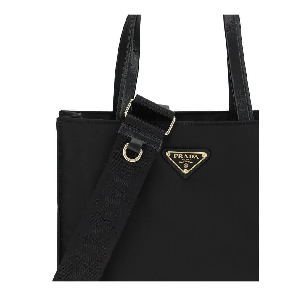 Black Recycled Polyamide Shoulder BagRe-Nylon Tote Bag by Prada features a functional and elegant design. Equipped with two leather handles, it features the iconic triangular plaque on the front and an adjustable and removable nylon shoulder strap for add