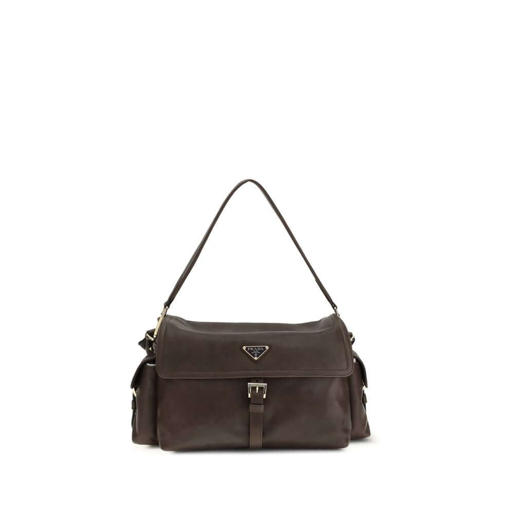 Brown Recycled Polyamide Shoulder BagExplore large Shoulder Bag by Prada is made of Re-Nylon and features a flap with a classic enameled metal triangle logo. It features a padded ribbon handle, front zipper pocket, side flap pockets, and metal trim. The c