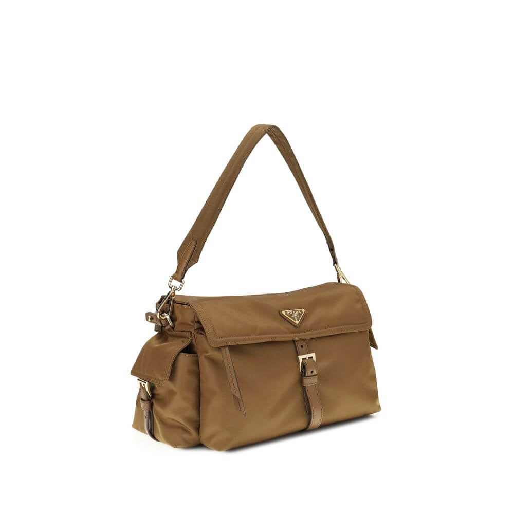 Brown Recycled Polyamide Shoulder BagExplore large Shoulder Bag by Prada is made of Re-Nylon and features a flap with a classic enameled metal triangle logo. It features a padded ribbon handle, front zipper pocket, side flap pockets, and metal trim. The c