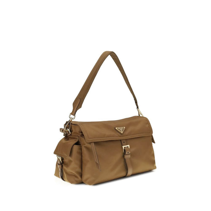 Brown Recycled Polyamide Shoulder BagExplore large Shoulder Bag by Prada is made of Re-Nylon and features a flap with a classic enameled metal triangle logo. It features a padded ribbon handle, front zipper pocket, side flap pockets, and metal trim. The c
