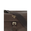 Brown Recycled Polyamide Shoulder BagExplore large Shoulder Bag by Prada is made of Re-Nylon and features a flap with a classic enameled metal triangle logo. It features a padded ribbon handle, front zipper pocket, side flap pockets, and metal trim. The c