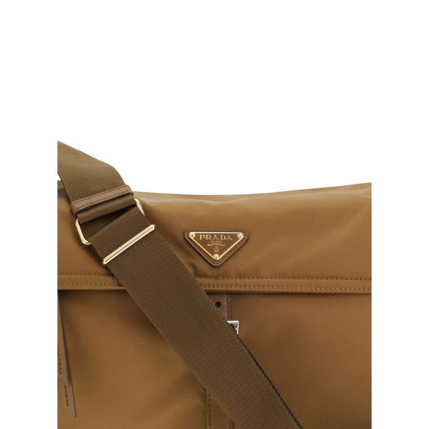 Brown Recycled Polyamide Shoulder BagExplore large Shoulder Bag by Prada is made of Re-Nylon and features a flap with a classic enameled metal triangle logo. It features a padded ribbon handle, front zipper pocket, side flap pockets, and metal trim. The c