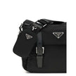 Black Polyamide Shoulder BagExplore medium Shoulder Bag by Prada is made of Re-Nylon and finished with metal details. It features a front zippered pocket, enameled triangle logo flap, and zipper and strap closure. The interior, also made of Re-Nylon, incl