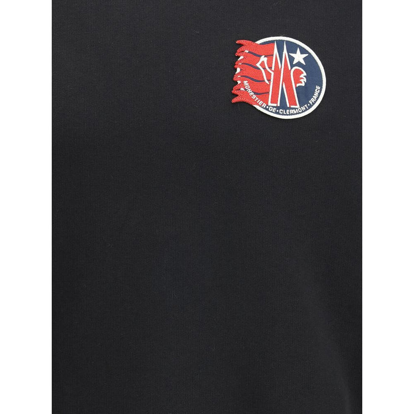 Black Cotton SweatshirtThe cotton hooded Sweatshirt by Moncler is a timeless casual essential reimagined with a distinctive touch. Crafted from soft cotton jersey, it features an adjustable hood, ribbed trims, and the iconic star-shaped logo patch on the