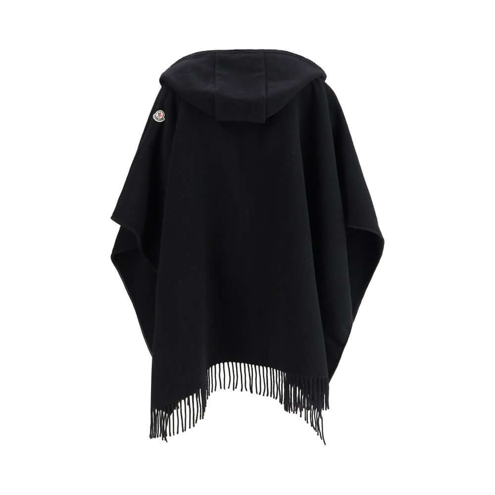 Wool CapeThe wool Cape by Moncler, defined by an elegant draped design that makes it a versatile layering piece for every season. Crafted from soft wool with light padding, it features a nylon laqué belt to define the silhouette, fringed edges, and the ic
