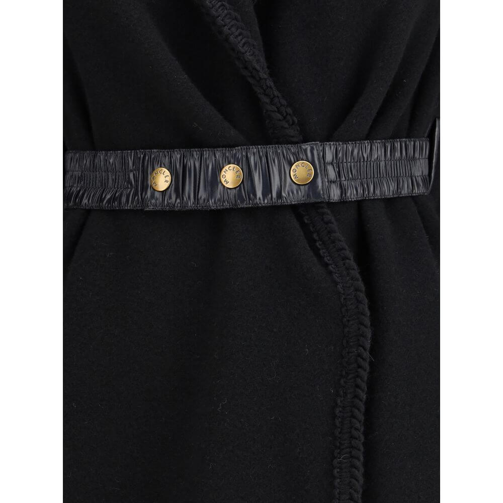 Wool CapeThe wool Cape by Moncler, defined by an elegant draped design that makes it a versatile layering piece for every season. Crafted from soft wool with light padding, it features a nylon laqué belt to define the silhouette, fringed edges, and the ic