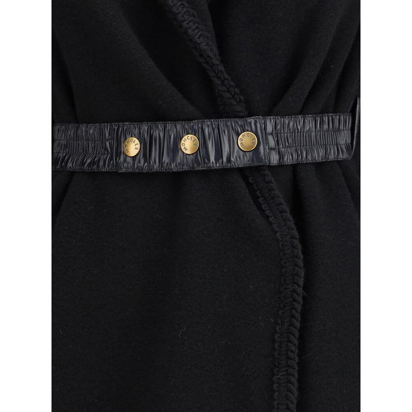 Wool CapeThe wool Cape by Moncler, defined by an elegant draped design that makes it a versatile layering piece for every season. Crafted from soft wool with light padding, it features a nylon laqué belt to define the silhouette, fringed edges, and the ic
