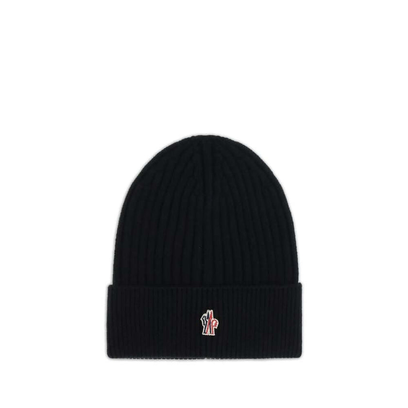 Black Fleece Wool BeanieBeanie Hat by Moncler Grenoble combines functionality and style in an essential cold-weather accessory. Made with ribbed fabrication, it offers a snug and comfortable fit. The Moncler Grenoble logo sewn on the front adds a distinct