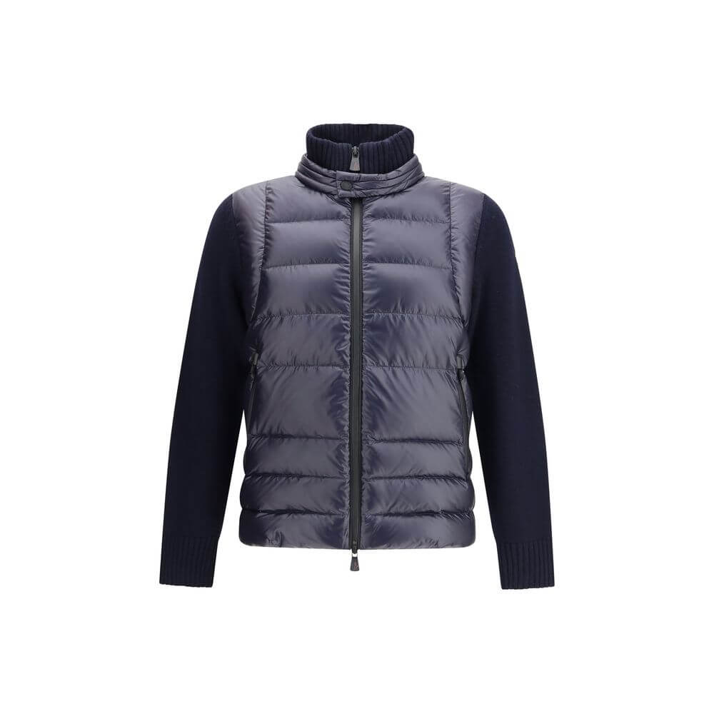 Panelled JacketThe panelled Jacket by Moncler Grenoble crafted from a wool blend, featuring a down-feather padded design that alternates quilted sections with knitted panels. It comes with a high neck, front zip fastening, long sleeves, and ribbed cuffs a