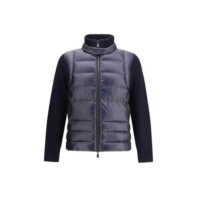 Panelled JacketThe panelled Jacket by Moncler Grenoble crafted from a wool blend, featuring a down-feather padded design that alternates quilted sections with knitted panels. It comes with a high neck, front zip fastening, long sleeves, and ribbed cuffs a