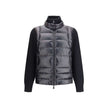 Panelled JacketThe panelled Jacket by Moncler Grenoble crafted from a wool blend, featuring a down-feather padded design that alternates quilted sections with knitted panels. It comes with a high neck, front zip fastening, long sleeves, and ribbed cuffs a