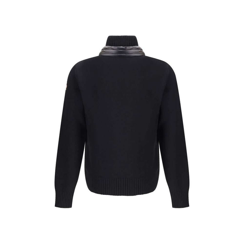 Panelled JacketThe panelled Jacket by Moncler Grenoble crafted from a wool blend, featuring a down-feather padded design that alternates quilted sections with knitted panels. It comes with a high neck, front zip fastening, long sleeves, and ribbed cuffs a