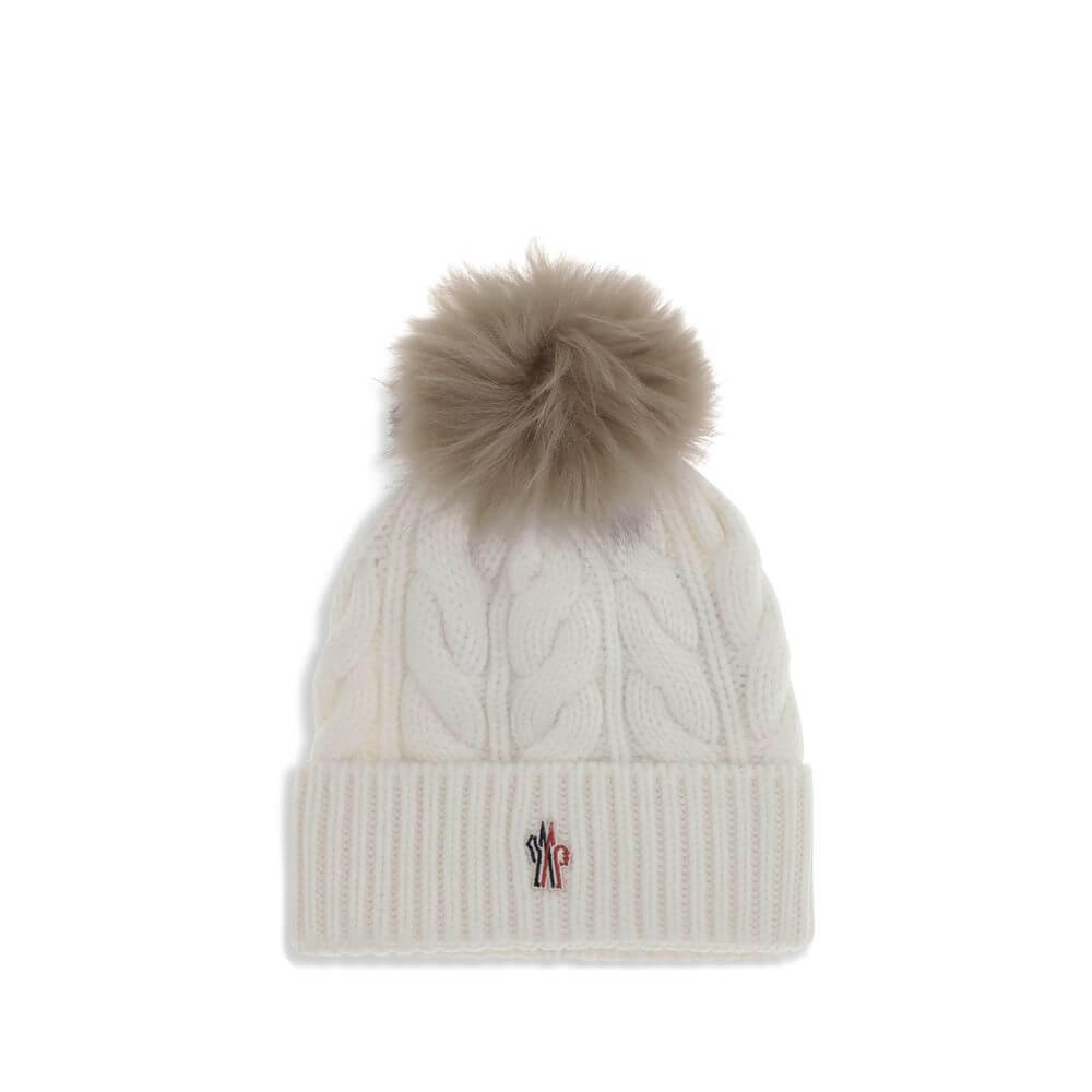 White Fleece Wool BeanieThe beanie Hat by Moncler Grenoble with pon pon is crafted from a premium wool and cashmere blend for warmth and comfort. It features a long-haired sheepskin pom pom and a 3-gauge Aran cable-knit cuff for a rich, detailed texture.