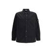 Black Cotton ShirtThe Stone Island Overshirt, crafted from 100% black cotton, is a versatile essential that blends functionality with contemporary style. Featuring a button fastening, two chest patch pockets, and the iconic logo patch on the left sleeve,