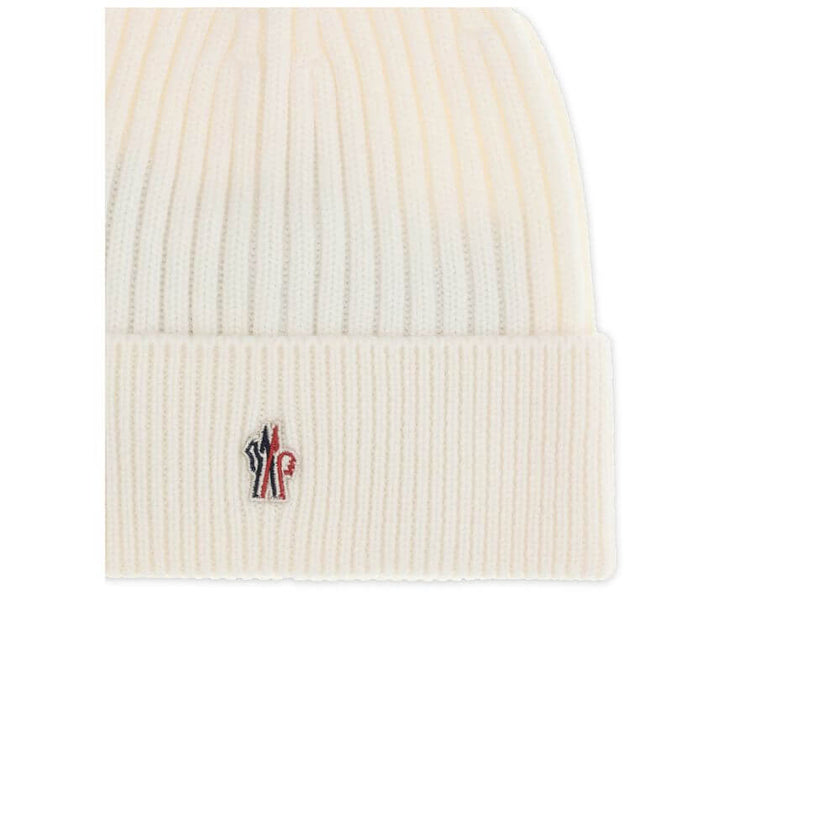 Cream Fleece Wool BeanieBeanie Hat by Moncler Grenoble combines functionality and style in an essential cold-weather accessory. Made with ribbed fabrication, it offers a snug and comfortable fit. The Moncler Grenoble logo sewn on the front adds a distinct