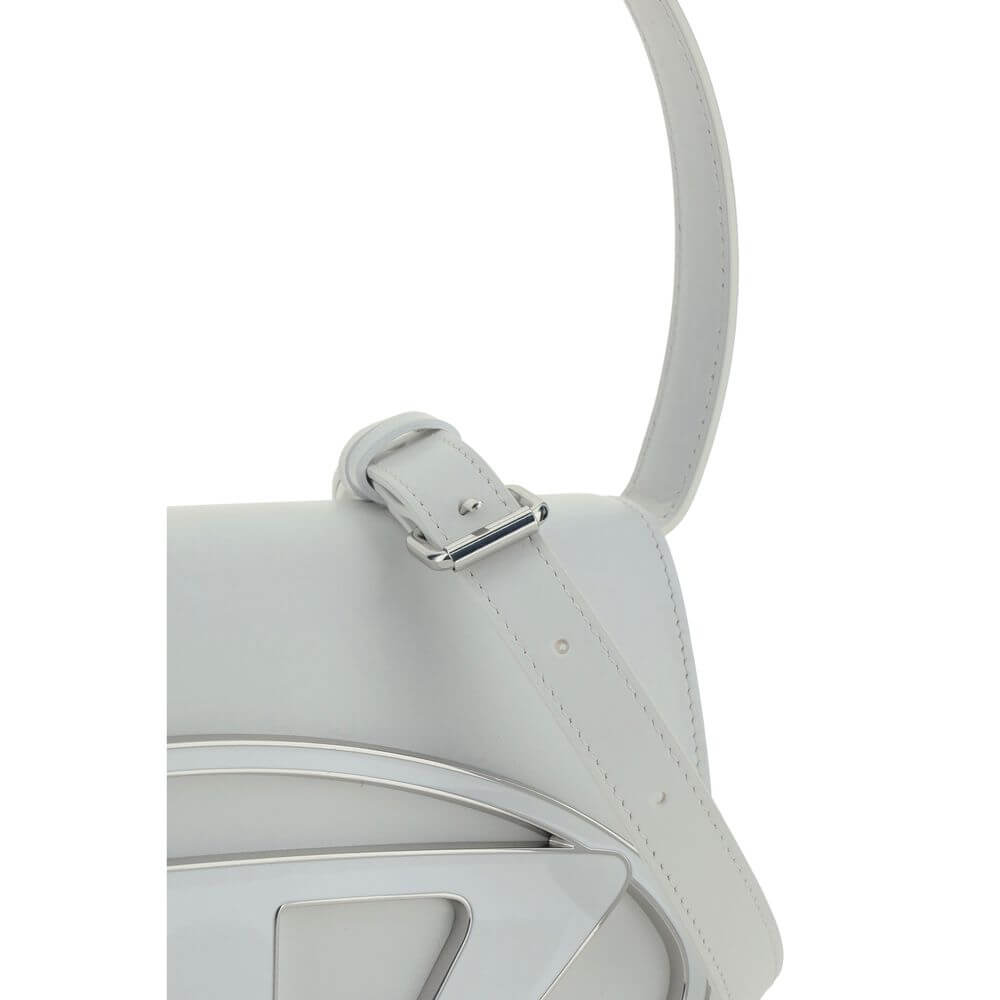 White Calf Leather Bos Taurus Shoulder BagThe 1DR Shoulder Bag by Diesel is made of mirrored leather with a flat shoulder strap. It has a front magnetic closure and the brand’s embossed Oval-D logo. Inside is a welt pocket to keep items in order. A modern