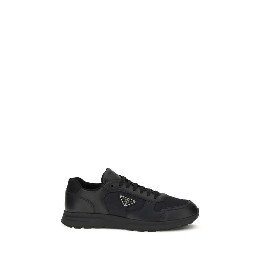 Black Recycled Polyamide Athletic SneakersSneakers by Prada, made of Re-Nylon and brushed leather, combine contemporary style and innovative materials. Equipped with laces, they feature an enameled triangle logo on the upper and screen-printed Prada Milan