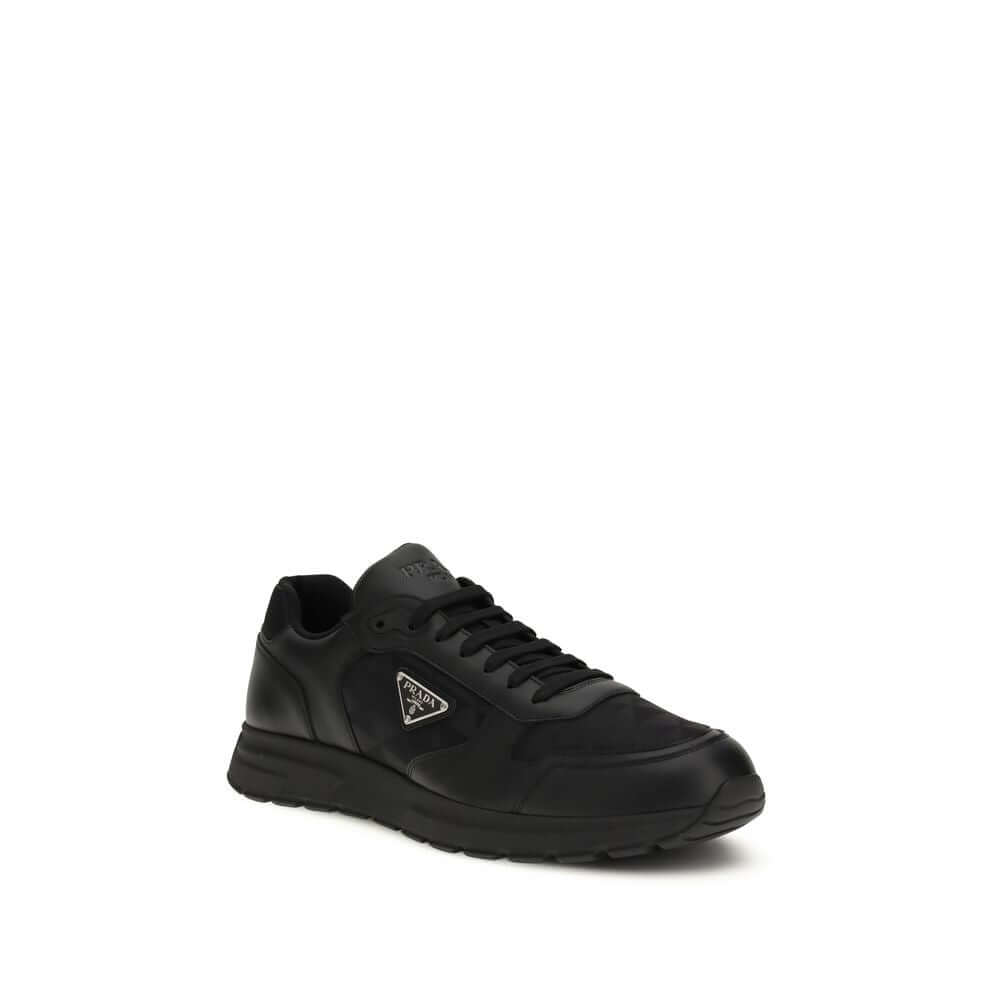 Black Recycled Polyamide Athletic SneakersSneakers by Prada, made of Re-Nylon and brushed leather, combine contemporary style and innovative materials. Equipped with laces, they feature an enameled triangle logo on the upper and screen-printed Prada Milan