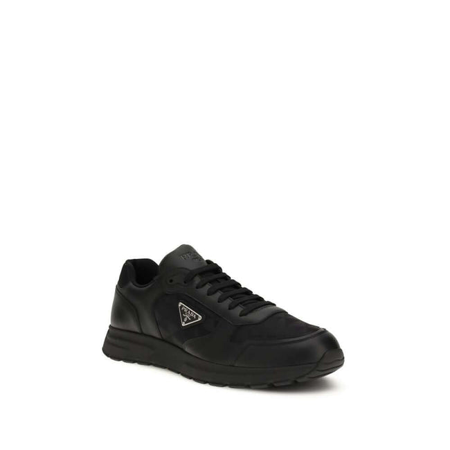 Black Recycled Polyamide Athletic SneakersSneakers by Prada, made of Re-Nylon and brushed leather, combine contemporary style and innovative materials. Equipped with laces, they feature an enameled triangle logo on the upper and screen-printed Prada Milan