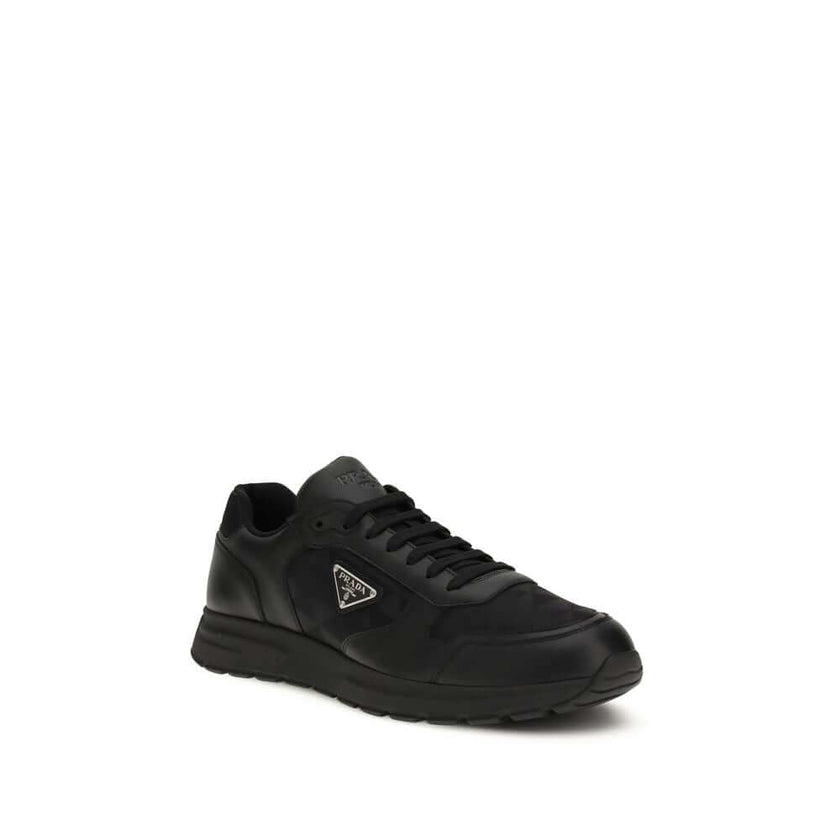 Black Recycled Polyamide Athletic SneakersSneakers by Prada, made of Re-Nylon and brushed leather, combine contemporary style and innovative materials. Equipped with laces, they feature an enameled triangle logo on the upper and screen-printed Prada Milan