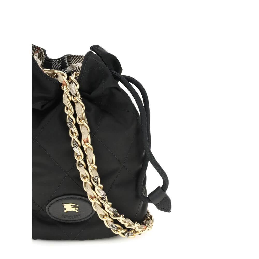 Black Nylon Shoulder BagHorseshoe Bucket Bag by Burberry is made of quilted canvas and embellished with the Equestrian Knight Design applique on the front. It features a metal chain shoulder strap and a drawstring closure, combining practicality and iconi