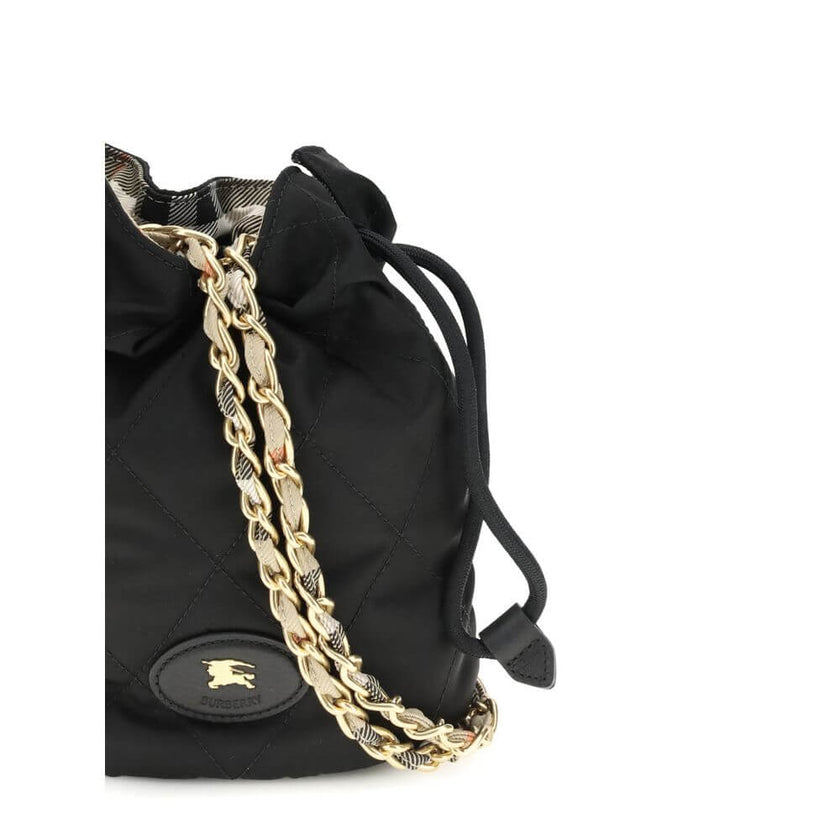 Black Nylon Shoulder BagHorseshoe Bucket Bag by Burberry is made of quilted canvas and embellished with the Equestrian Knight Design applique on the front. It features a metal chain shoulder strap and a drawstring closure, combining practicality and iconi
